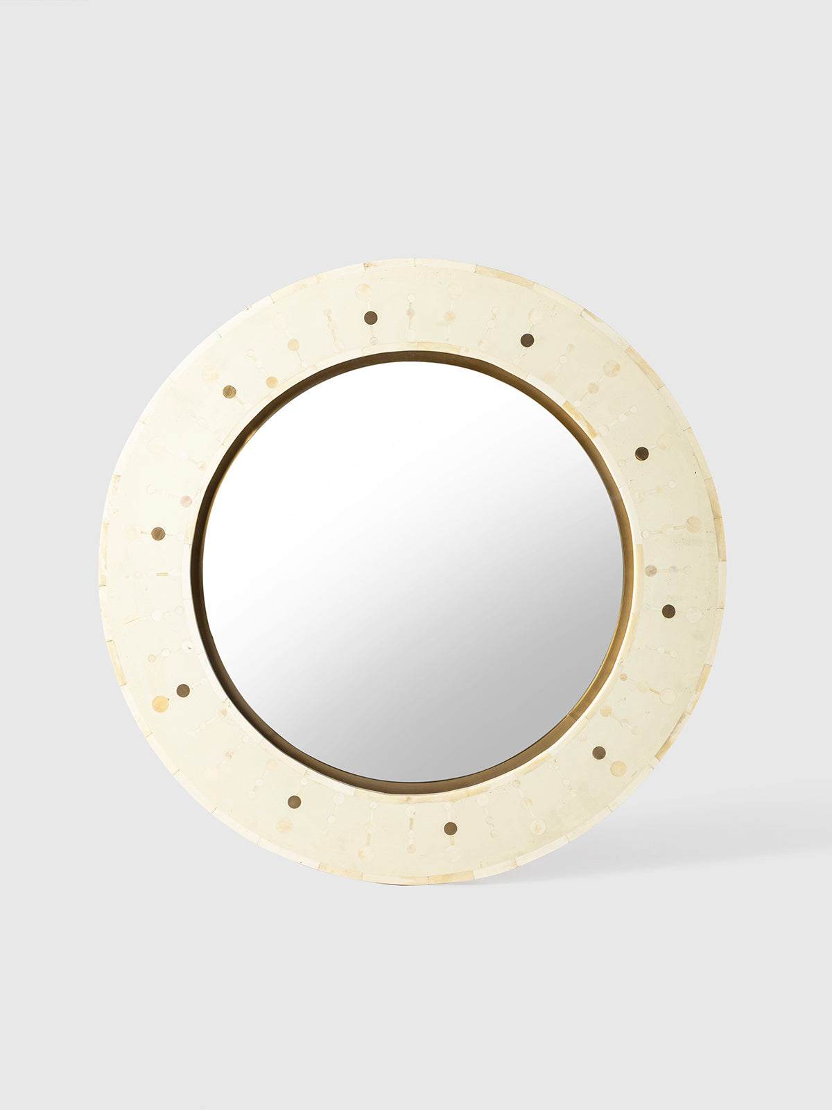 Round mirror with a beige frame on a light gray background