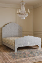 Decorative bone inlay bed with intricate design in a room with a chandelier.
